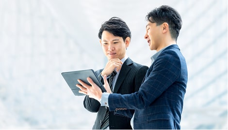 タブレットを見ながらビジネスの打ち合わせをする2人の男性